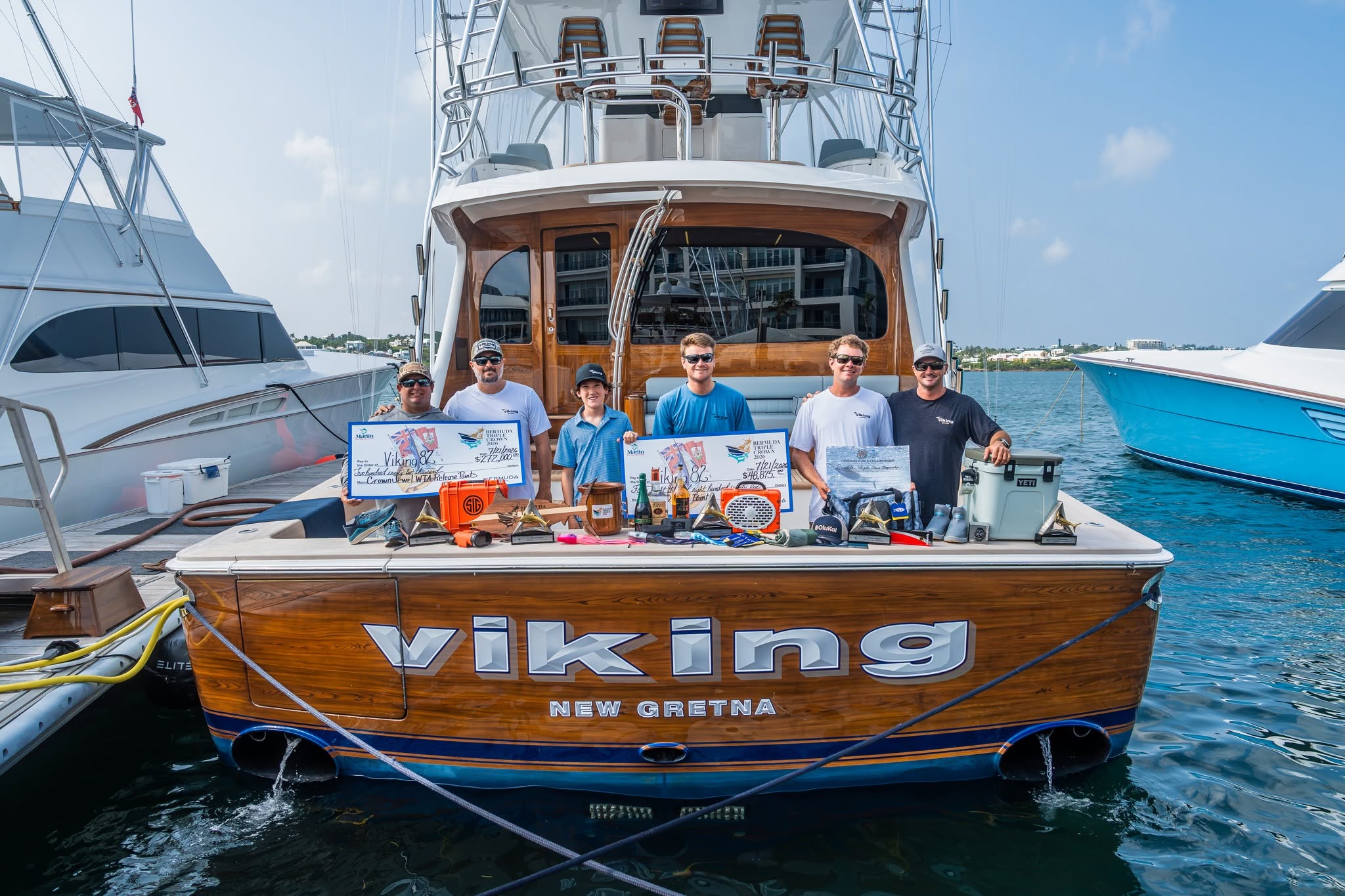 Viking crew posing behind the boat transom with tournament awards